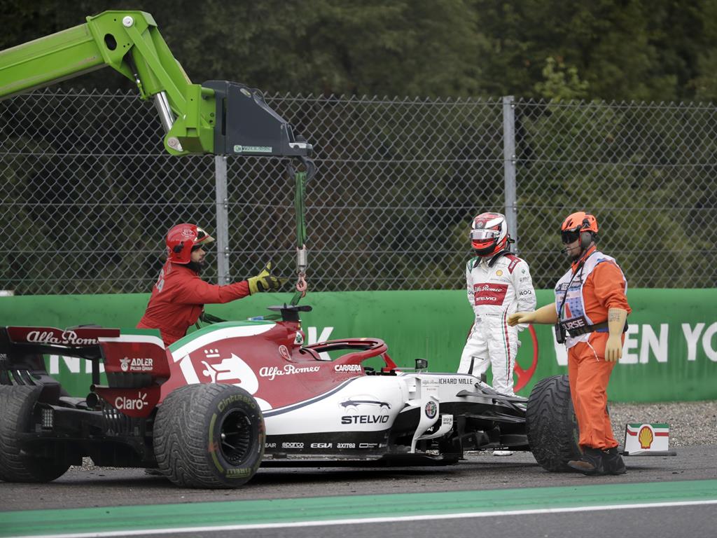 Lost control: Raikkonen watches as a crane lifts his Alfa Romeo from the gravel PICTURE: PA