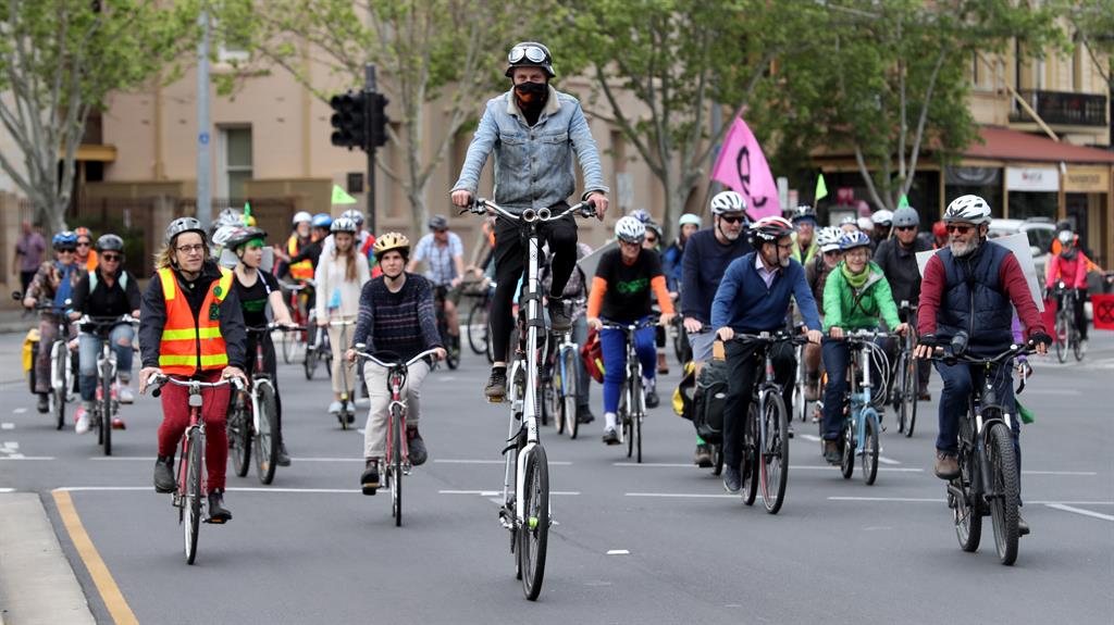 High rise: Extinction Rebellion activists ride their bikes through the central business district of Adelaide, South Australia PICTURE: EPA