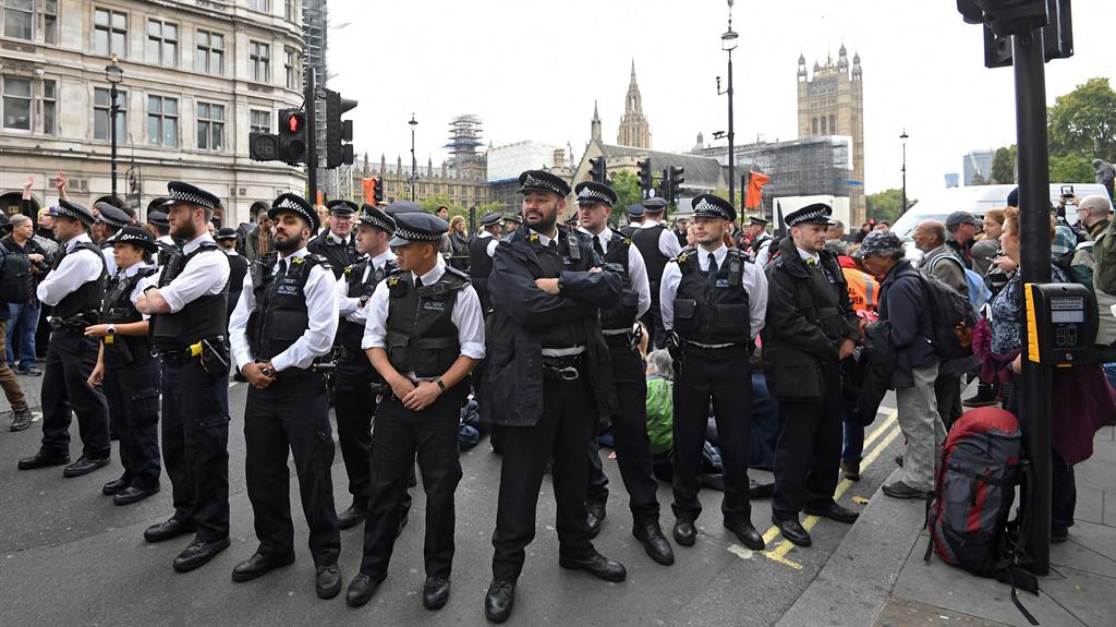 Nothing to see here: Police stand around Extinction Rebellion supporters blocking the road in Westminster PICTURE: EPA