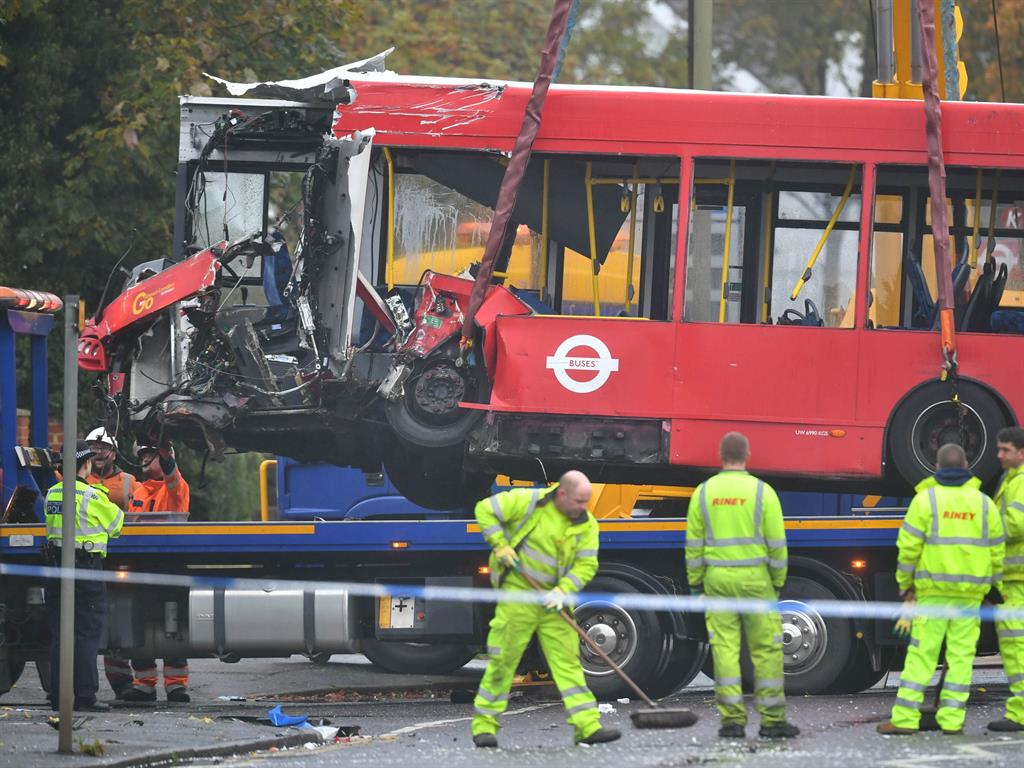 'Almighty smash': Police and recovery workers remove a damaged bus from the scene of the crash in Sevenoaks Road, Orpington