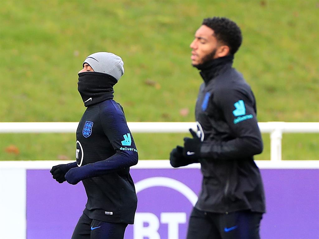 Focused: Raheem Sterling and Joe Gomez stretch their legs after an altercation yesterday PICTURE: PA