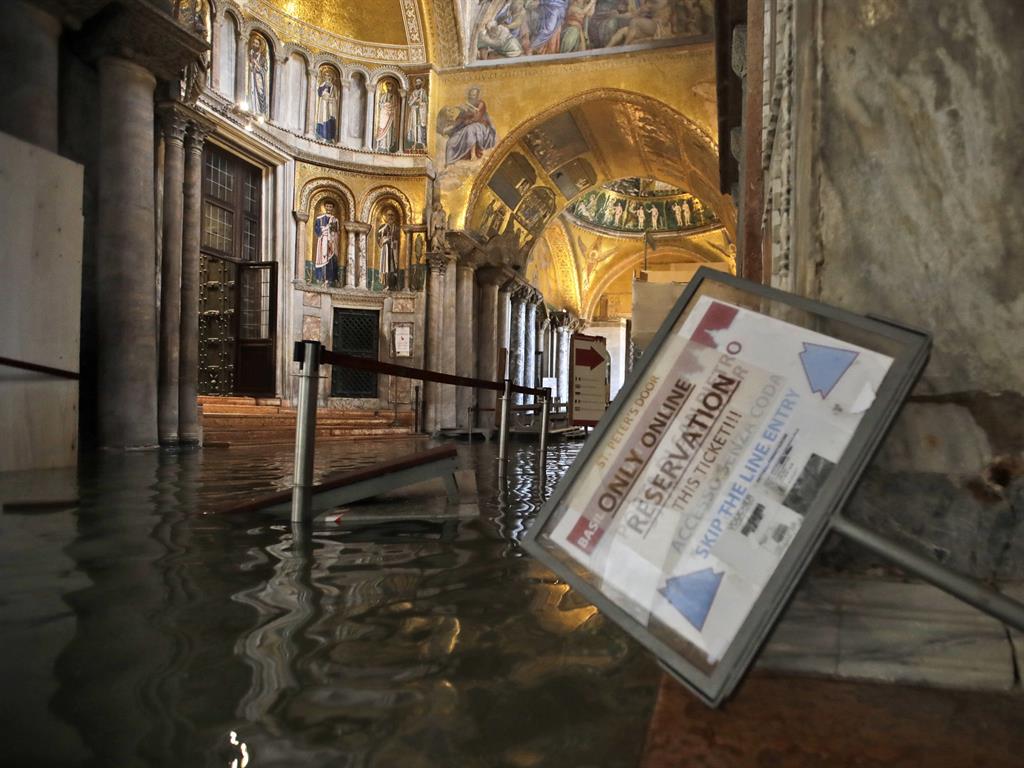 Untold damage: High water floods the inside of St. Mark's Basilica. Below, the view outside PICTURES: AP