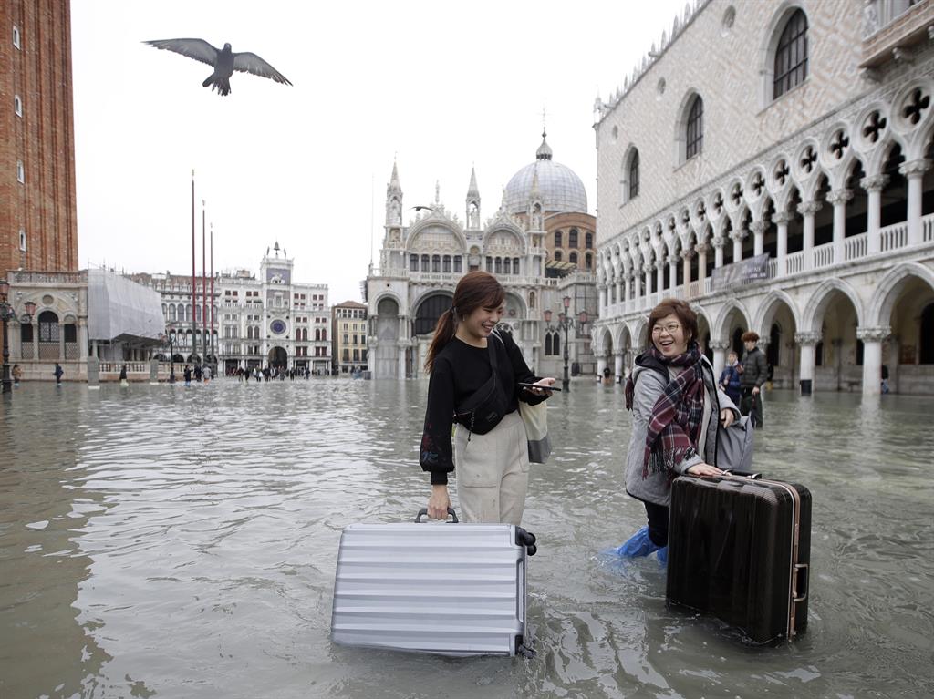 Welcome to Venice: Tourists push their luggage in a flooded St. Mark's Square PICTURE: AP