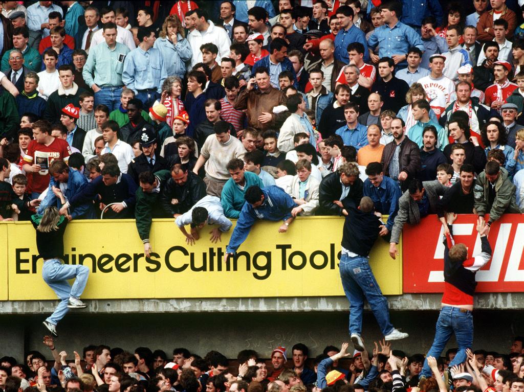 Helping hands: Some Liverpool fans were pulled to the safety of the upper tier PICTURE: GETTY