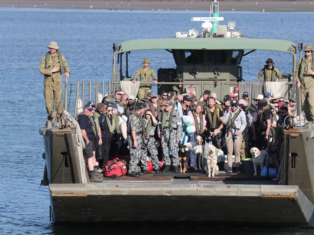Safe at last: Evacuees from the cut-off coastal town of Mallacoota are brought ashore by landing craft at Hastings, Victoria PICTURE: EPA