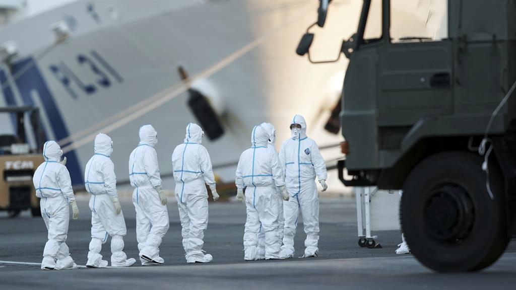 Got it covered: Officials in protective suits at work ashore from the Diamond Princess in Yokohama, Japan