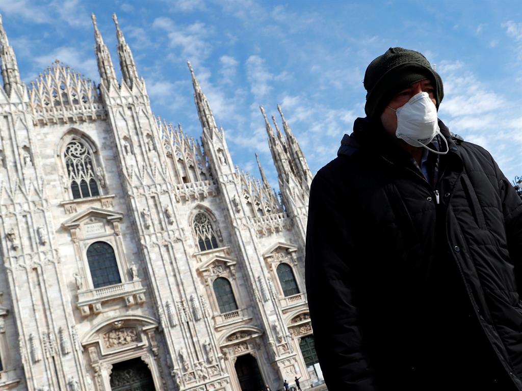 Global scare: A man wearing a protective face mask in Milan PICTURES: REUTERS