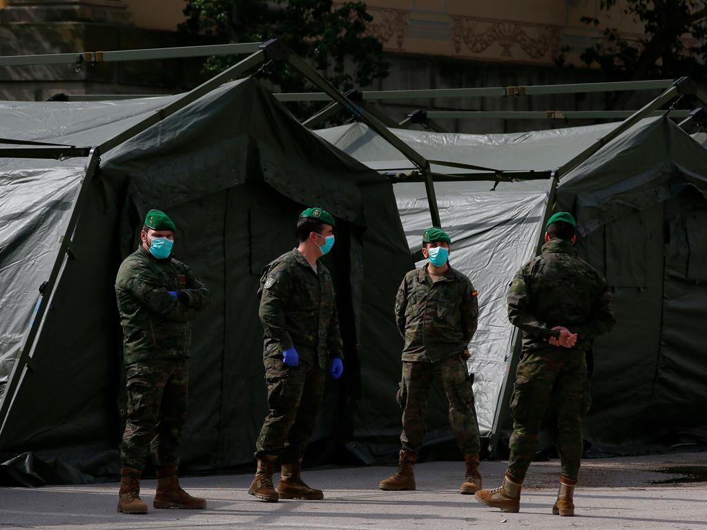 Out in force: Soldiers in face masks stand outside hospital set up in trade centre