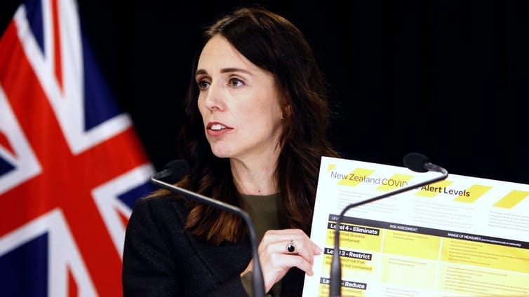 Ambitious goal: New Zealand prime minister Jacinda Ardern holds up a map showing a new warning system for Covid-19 in Wellington. Her country intends to not only contain the coronavirus but eliminate it completely PICTURE: AP/NICK PERRY