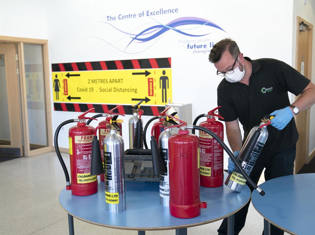 Firing on all cylinders: Extinguishers are checked at a school in Stockport PICTURE: REX