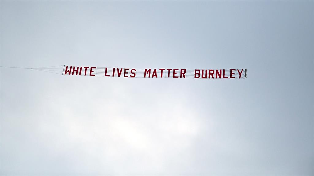 Flying shame: Banner is flown over Manchester City’s Etihad stadium moments after players took the knee PICTURE: EPA