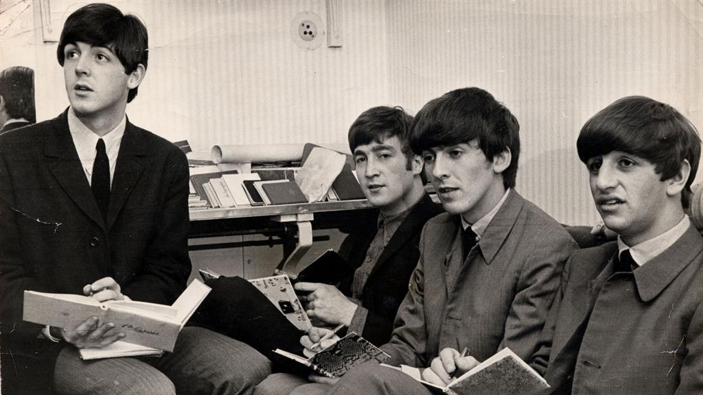 Pen to paper: The Beatles signing autographs in their dressing room in 1963, the same year that Pamela's own book was signed PICTURE: REX