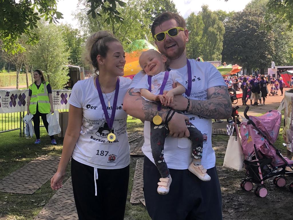 Proud parents: Clara gets to take the weight off her feet after completing the challenge