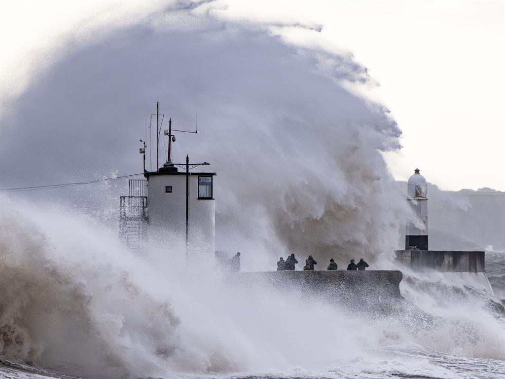 Battered: Waves crashing against the harbour wall in Porthcawl, Wales, on Friday PICTURE: GETTY