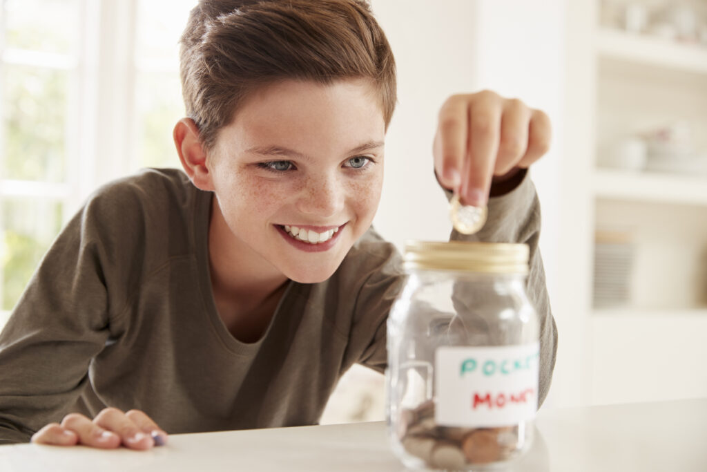 Providing Financial Security For Our Children - boy putting money in jar