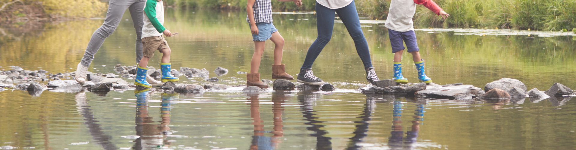 free UK family days out - family crossing stepping stones across river