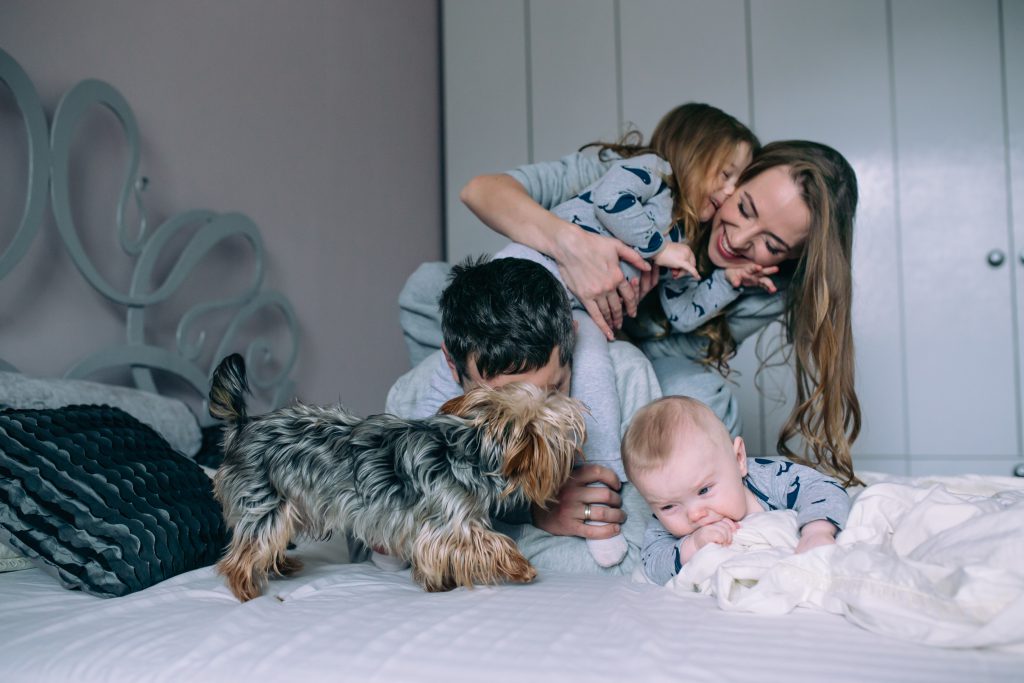 family playing on bed - mattress topper FAQs