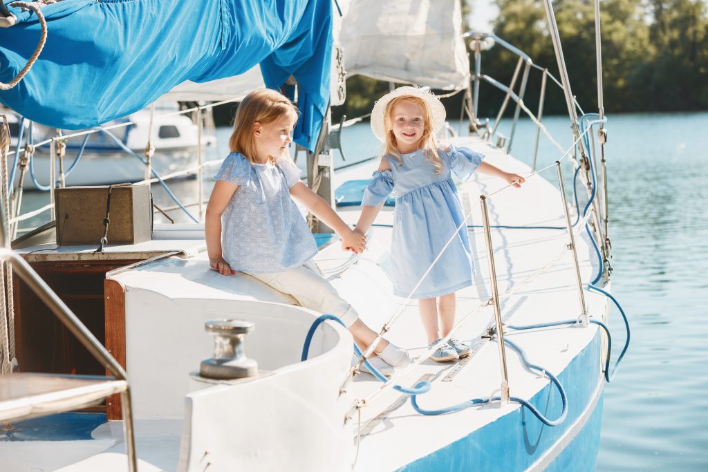 Boating Holidays with Children - two young girls sat on a yacht