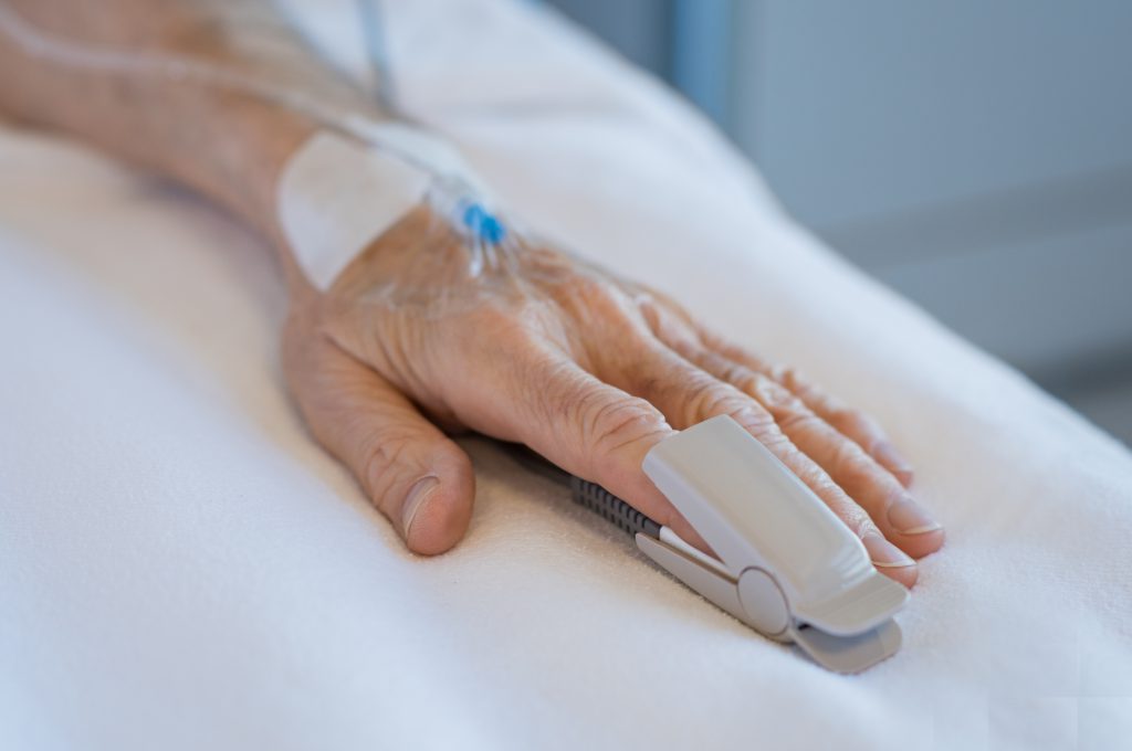 PAtient's hand on hospital bed, with syringe. family’s medical negligence rights