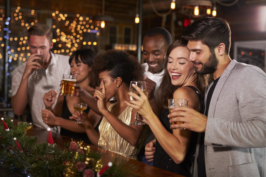 friends drinking in a bar at Christmas. Taken from blog post titled Planning A Christmas Night Out When You're Self Employed