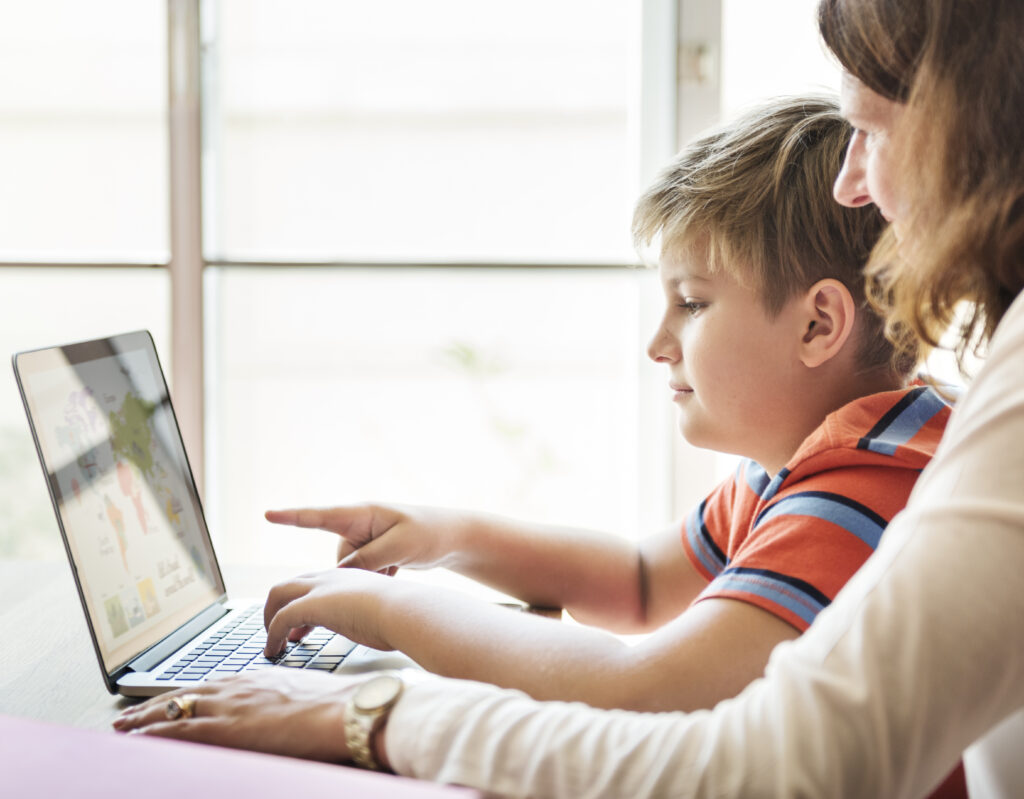 mum playing on a laptop with son to help him make it as a game designer