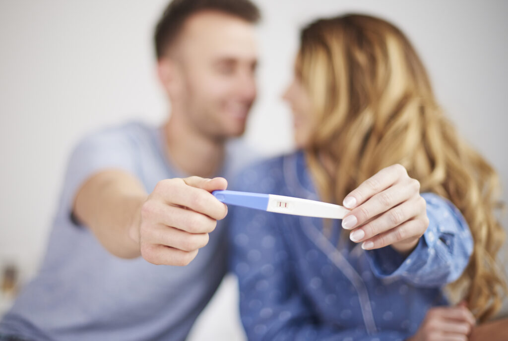 couple holding pregnancy test - considering my fertility now I'm separated