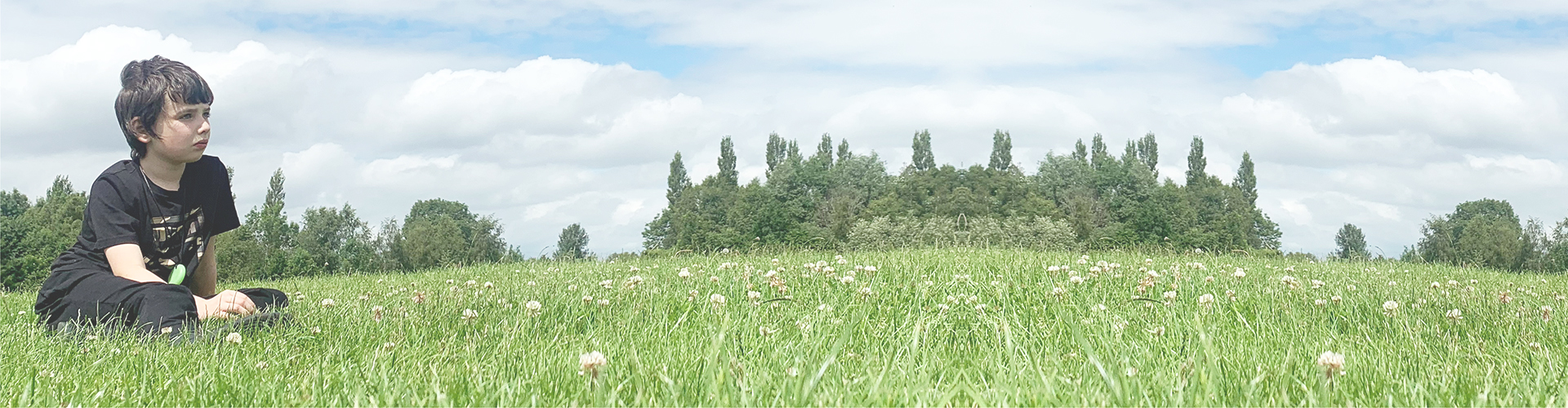 Sam sat on a field, staring out at the sky