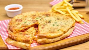 Two pizzas with a lasagne sandwiched inside now being sold by UK pub chain