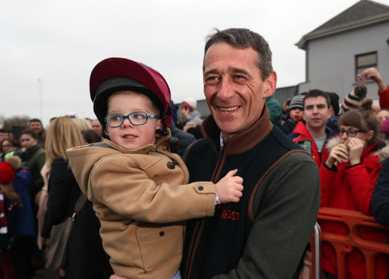 Davy Russell with his son Finn during the Tiger Roll's parade through Summerhill, County Meath, Ireland