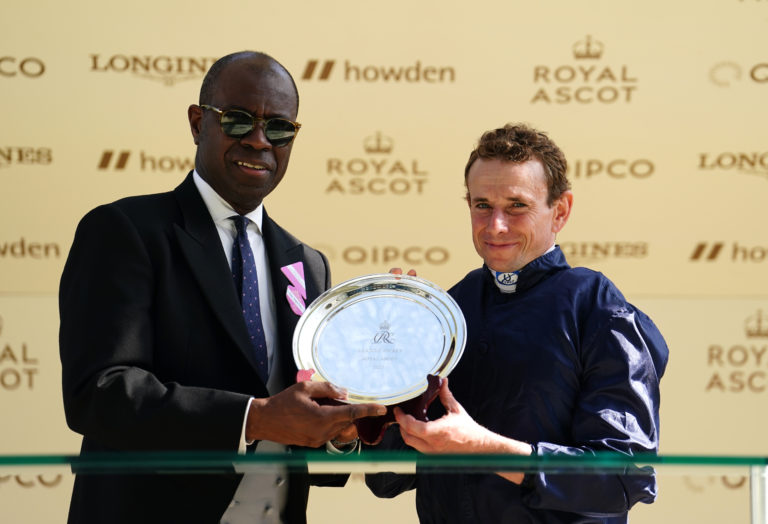TV presenter Clive Myrie presents the leading jockey trophy to Ryan Moore