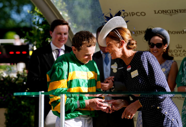 Catherine Dettori presents Ryan Moore with his award after winning the Queen Alexandra Stakes