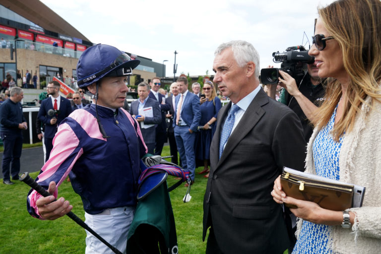 Jamie Spencer speaks with owners Stephen Hillen and Rebecca Hillen after riding Via Sistina to victory