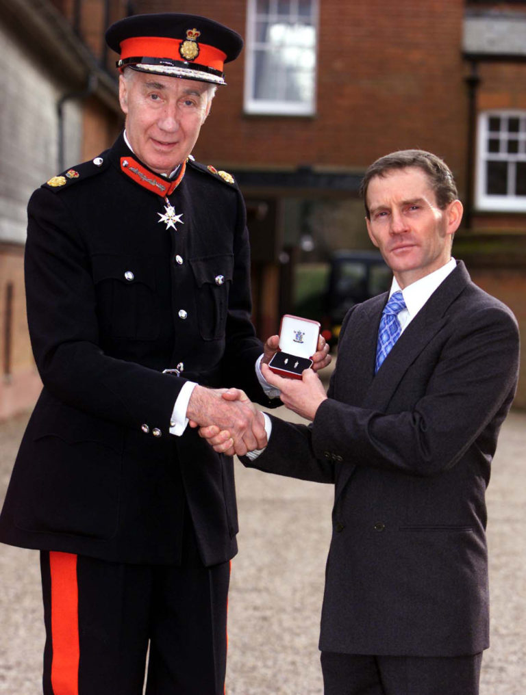Ray Cochrane holding the Queen's Commendation for Bravery presented to him by HM Lord Lieutenant of Suffolk, Lord Belstead