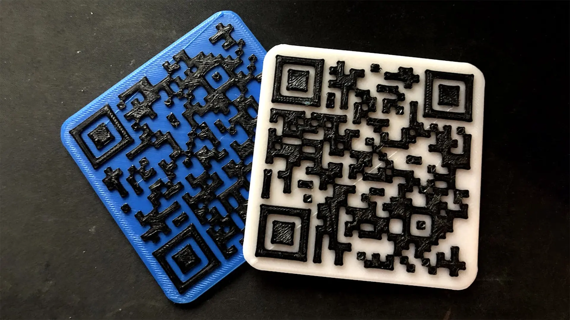 Photograph of two QR Code coasters overlapping in White and Blue PLA material.