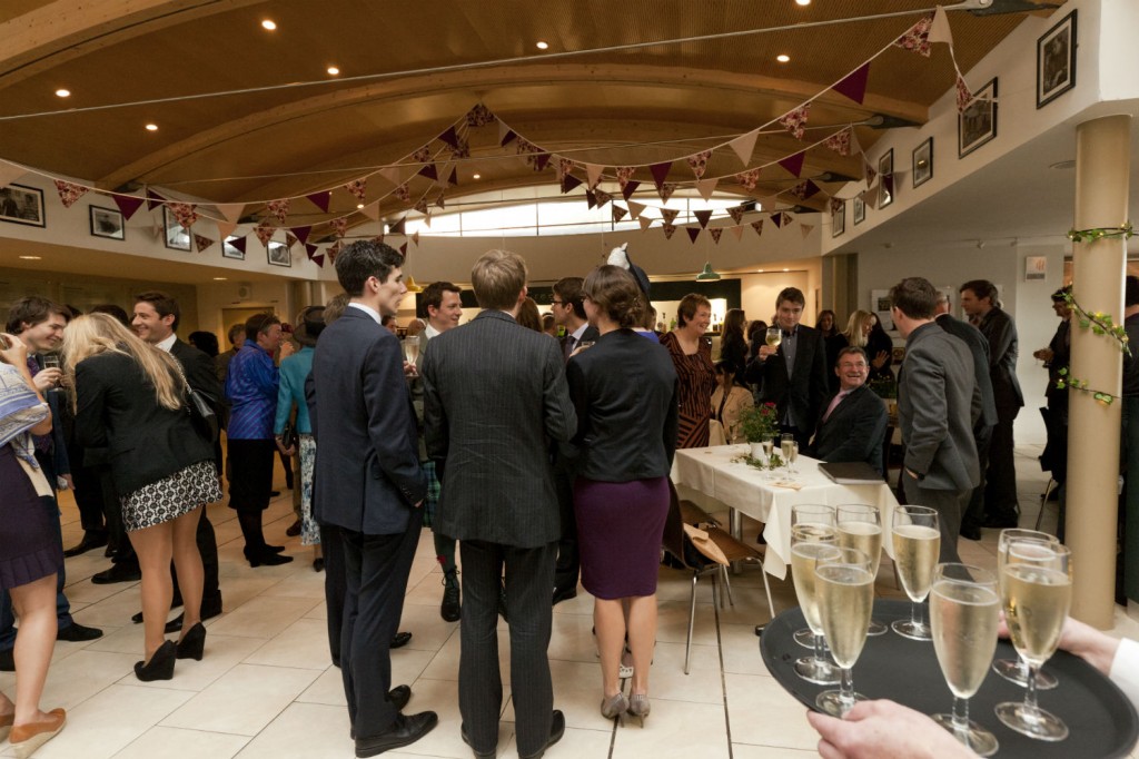 People gathered in the Greene Room bar with glasses of Champagne being served