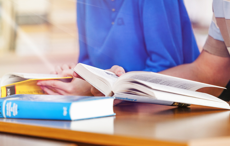 Two people reading textbooks