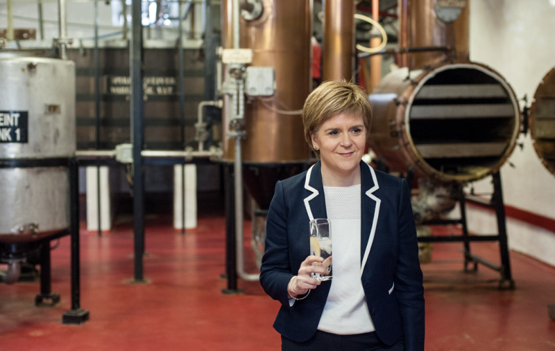 Nicola Sturgeon holding a drink in a distillery