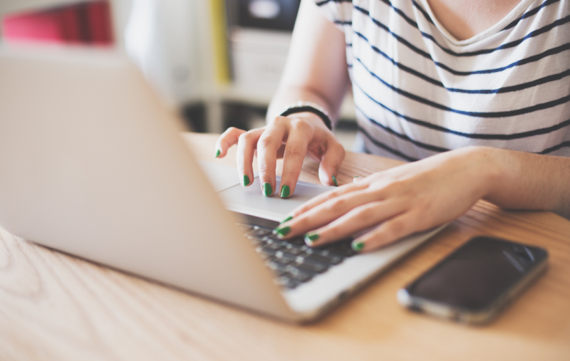 A woman typing on a laptop