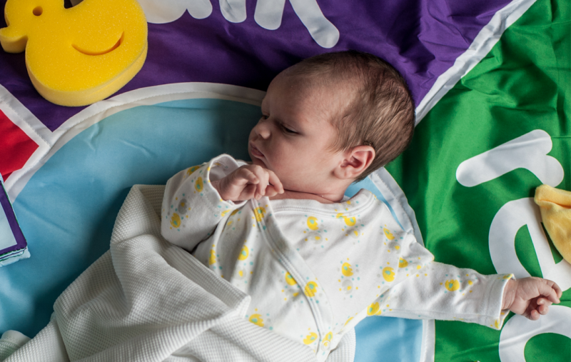 A baby lying on a mat